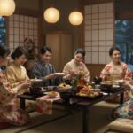 On a winter's day, several families wearing kimono gather together in a Japanese-style room over New Year's dishes and chatting peacefully.